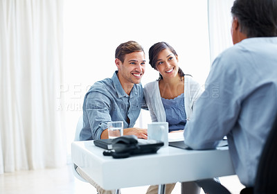 Buy stock photo Portrait of young couple listening to financial advisor in office