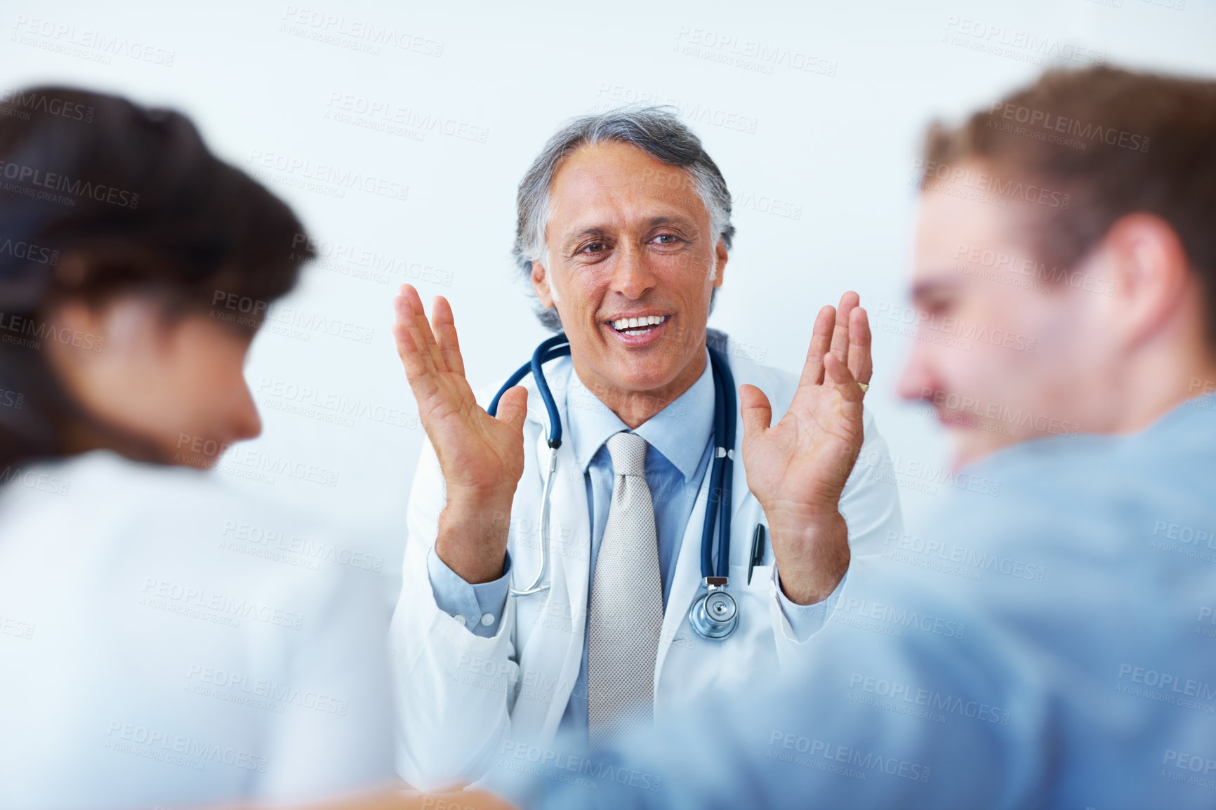Buy stock photo Portrait of happy mature doctor explaining to his young patients