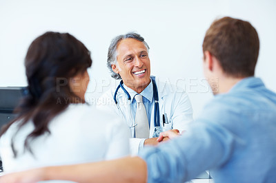 Buy stock photo Portrait of successful mature doctor shaking hands with young patient in clinic