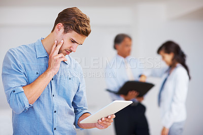 Buy stock photo Portrait of busy male executive using electronic tablet with coworkers in background