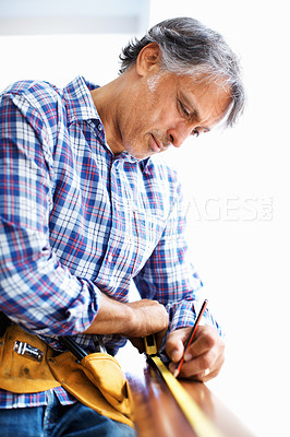 Buy stock photo Mature architect working with pencil and tape measure
