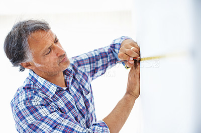 Buy stock photo Closeup of mature architect taking measurement on the wall