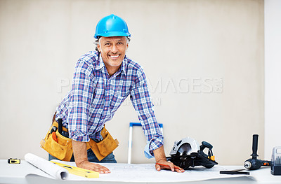 Buy stock photo Portrait of smiling mature engineer reviewing blueprint