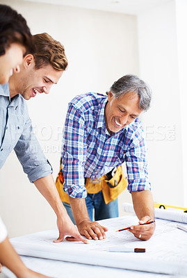 Buy stock photo Happy young couple looking at blueprint with engineer while discussing home renovation