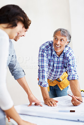 Buy stock photo Mature engineer explaining construction plan to young couple