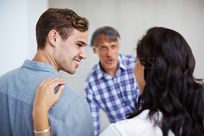 Buy stock photo Young couple discussing with mature man in background