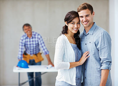 Buy stock photo Portrait of content young couple smiling with architect in background