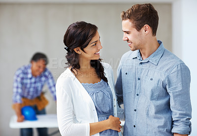 Buy stock photo Closeup of smiling young couple with architect in background