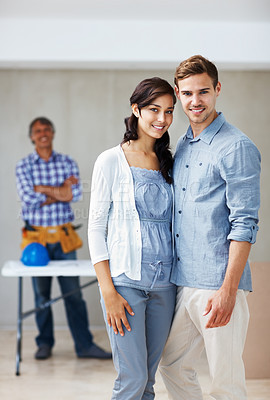 Buy stock photo Portrait of beautiful young couple smiling together with architect in background