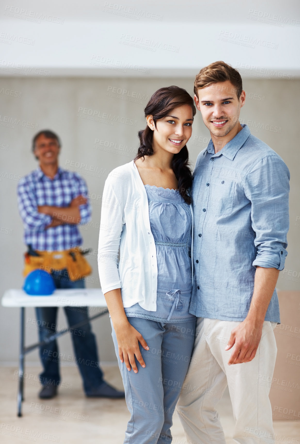 Buy stock photo Portrait of beautiful young couple smiling together with architect in background