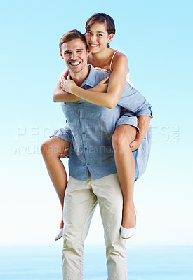 Buy stock photo Outdoor, couple and happy with piggyback on portrait with love, trust and support in Spain. People, relationship and smile in ocean on holiday or vacation for honeymoon, relax and break for bonding