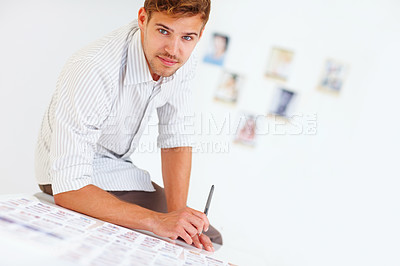 Buy stock photo Portrait of handsome photographer sitting on table with photos