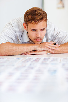 Buy stock photo Smart male photographer sitting at table and viewing photos
