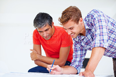 Buy stock photo Young professional photographer discussing with his colleague at work