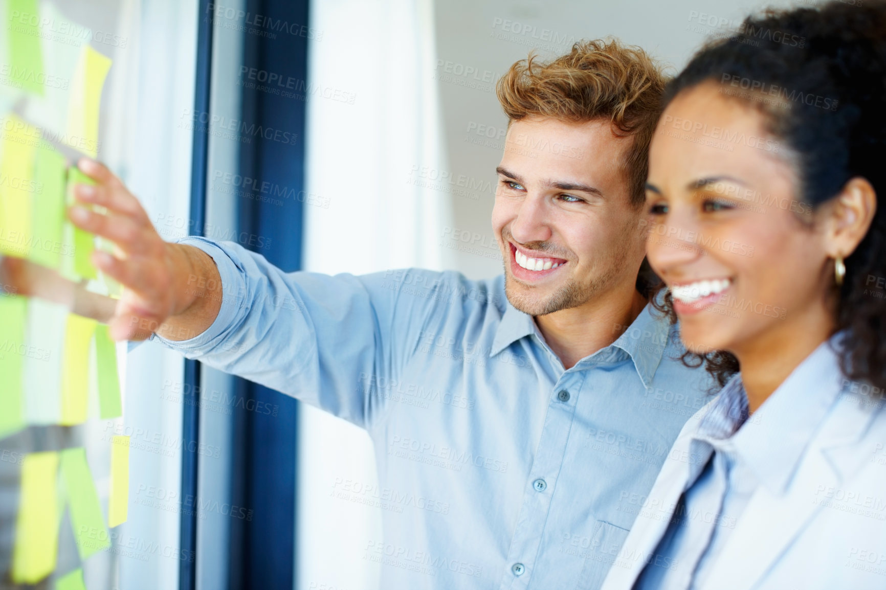 Buy stock photo Smiling business man and woman reading adhesive notes on glass