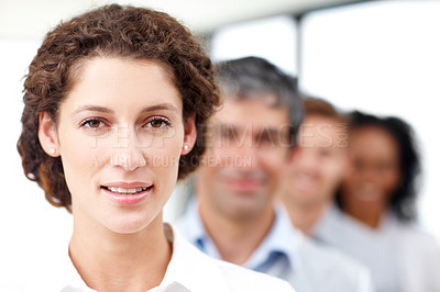 Buy stock photo Closeup portrait of a young female professional with her coworkers standing behind her