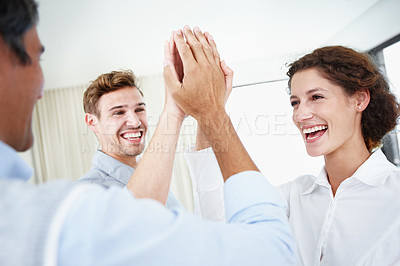 Buy stock photo Shot of a group of young business people hi-fiving each other