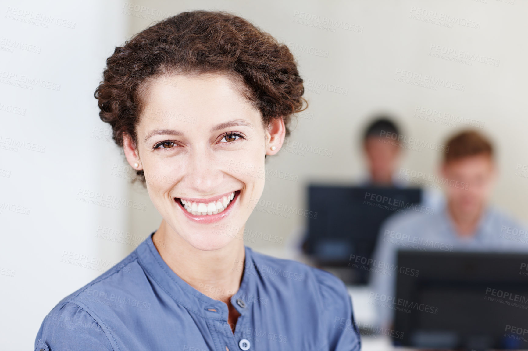 Buy stock photo Closeup portrait of a smiling young businesswoman with her colleagues sitting in the background