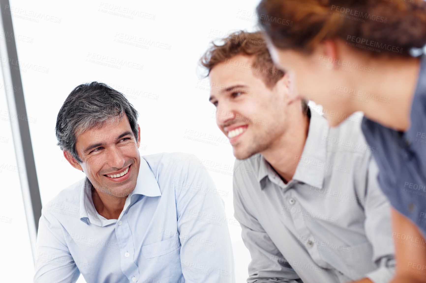 Buy stock photo Shot of three positive-looking businesspeople talking together in a meeting