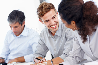 Buy stock photo Shot of three positive-looking businesspeople talking together in a meeting