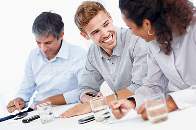 Buy stock photo Shot of three positive-looking businesspeople talking together in a meeting