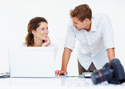 Buy stock photo Smiling business people using laptop and looking at each other with camera in foreground