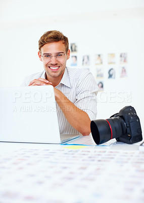 Buy stock photo Portrait of young photographer using laptop and smiling