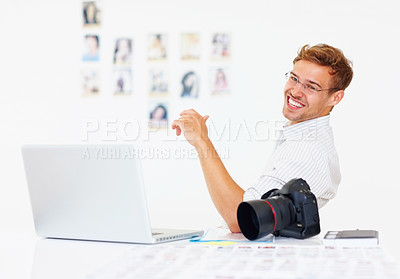 Buy stock photo Portrait of happy photographer with laptop and camera on table