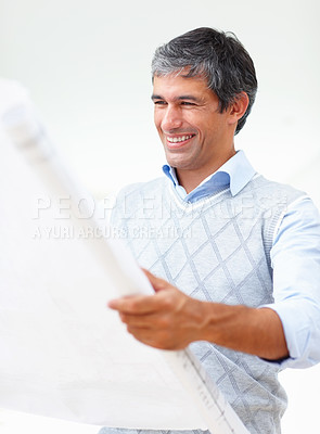 Buy stock photo Portrait of successful business man looking at blueprint on white background