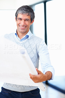 Buy stock photo Portrait of smiling mature male architect reviewing blueprint