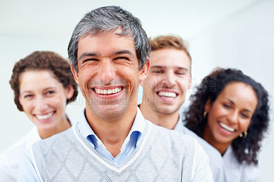 Buy stock photo Portrait of mature business man smiling with team in background