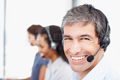 Buy stock photo Closeup portrait of a call center professional with colleagues seated in the background