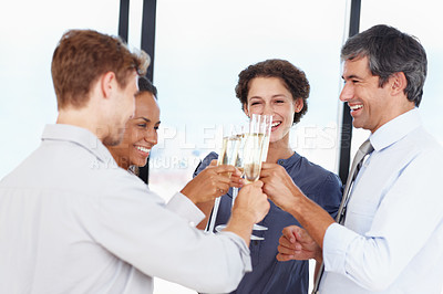 Buy stock photo Shot of a group of businesspeople toasting to their success with champagne