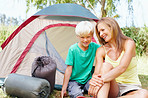 Mother and son sitting in front of tent