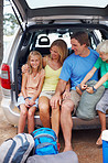 Young girl sitting in the back of a car with family