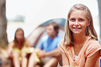 Young girl smiling while camping with family