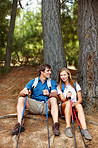 Couple sitting against tree and taking a break from trekking