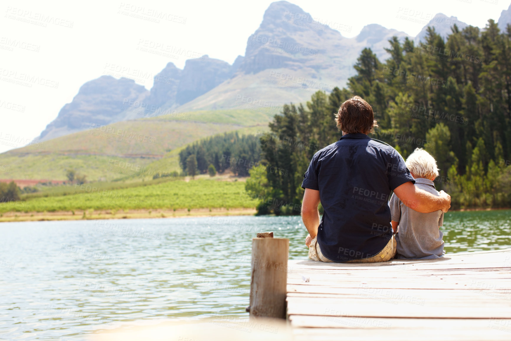 Buy stock photo Father, boy and bonding by lake for travel, vacation and relax together in summer with back by dock. Man, child and relationship in nature for adventure, holiday and support while camping with hug