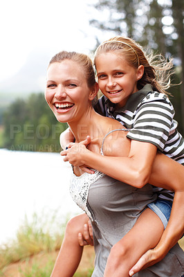 Buy stock photo Mom, girl and piggyback portrait by river, happiness and laughing for outdoor adventure in nature. Mother, daughter and carrying support or games by lake, love and bonding on holiday for connection