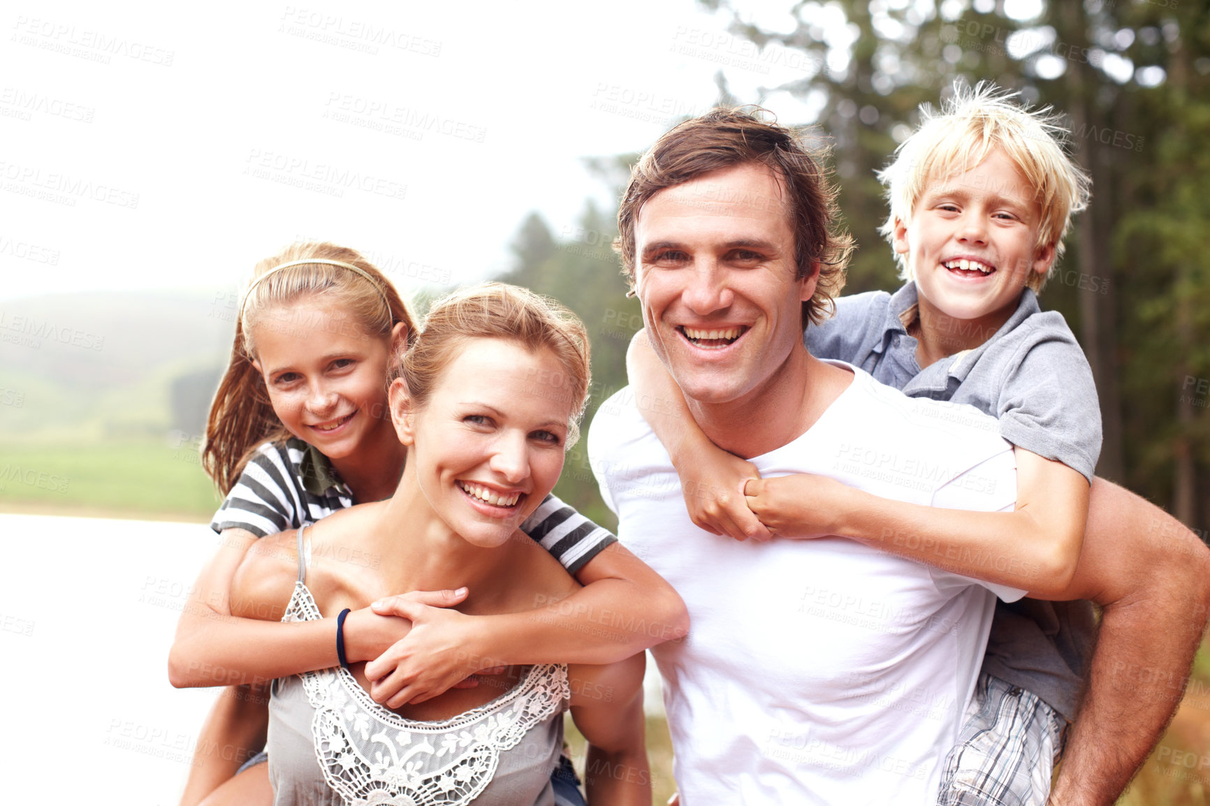 Buy stock photo Family, piggyback and happy outdoor portrait, lake holiday and bonding together on weekend trip. Parents, children and carrying kids for support on vacation, love and laughing for fun by river water