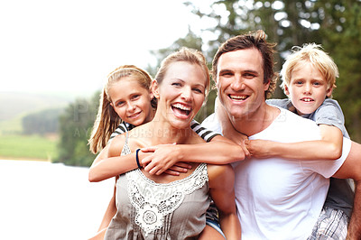 Buy stock photo Family, piggyback and laugh in outdoor portrait, lake holiday and bonding together on weekend trip. Parents, children and carrying kids for support on vacation, love and smile for fun by river water