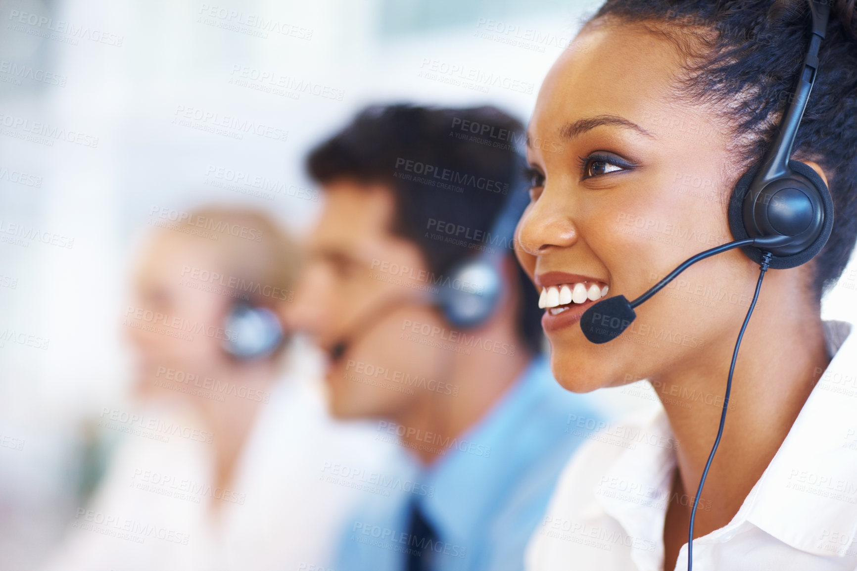 Buy stock photo Closeup of African American operator on call with colleagues in background