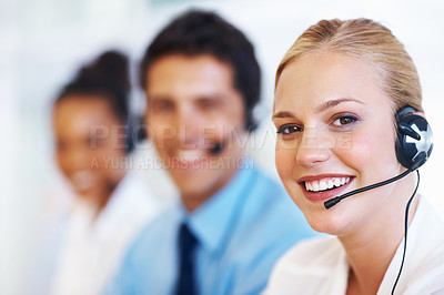 Buy stock photo Closeup of pretty female operator smiling with colleagues at call center