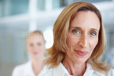Buy stock photo Closeup of pretty mature business woman smiling with female executive in background
