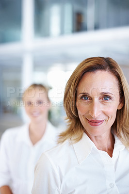 Buy stock photo Portrait of mature business woman smiling with female executive in background
