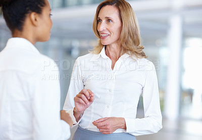 Buy stock photo Women, manager and talking together in office, partnership and consulting mentor in team conversation. Employees, communication and advice for support in workplace, collaboration and lobby discussion