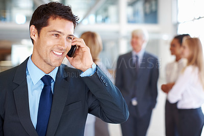 Buy stock photo Portrait of charming young business man on call with executives discussing in background