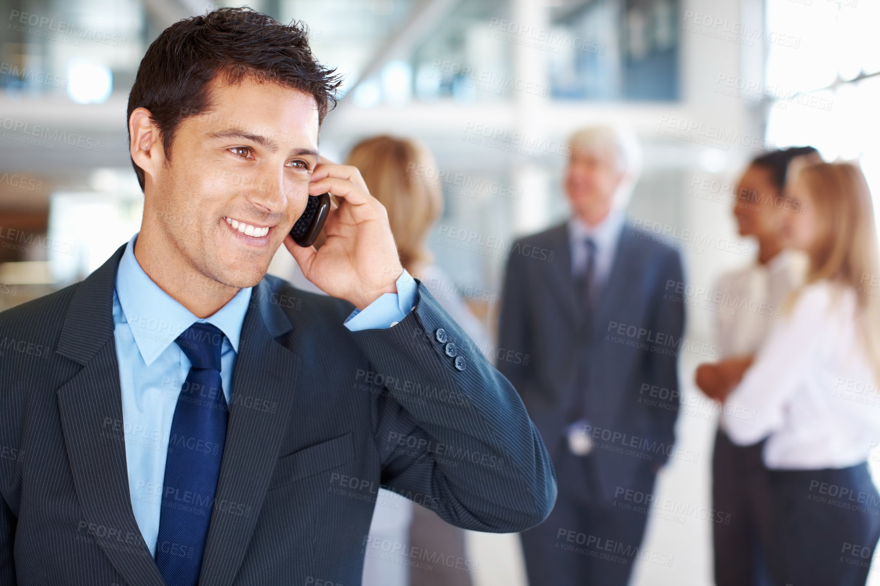 Buy stock photo Portrait of charming young business man on call with executives discussing in background