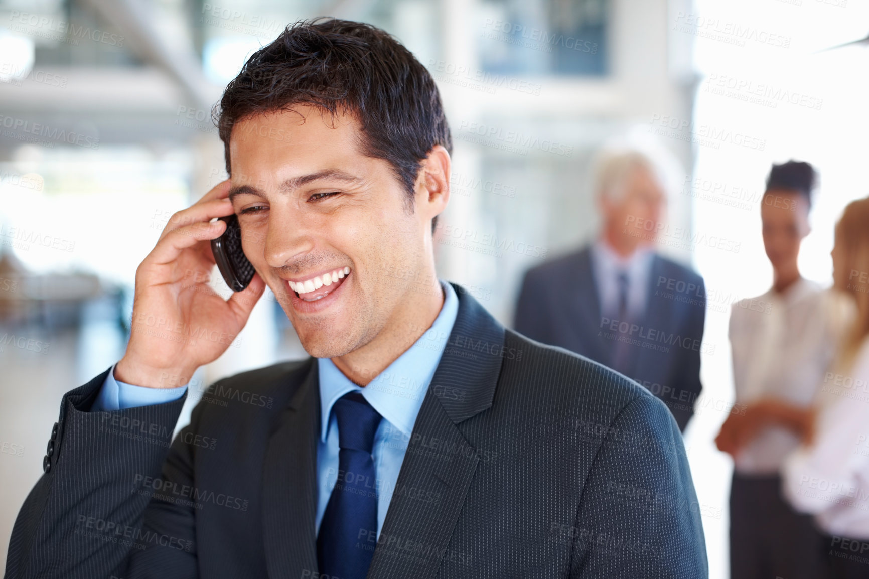 Buy stock photo Portrait of happy young business man on call with executives discussing in background
