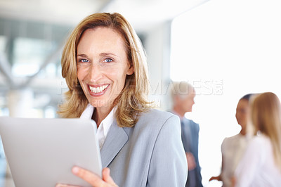 Buy stock photo Portrait of mature business woman working on electronic tablet with executives in background